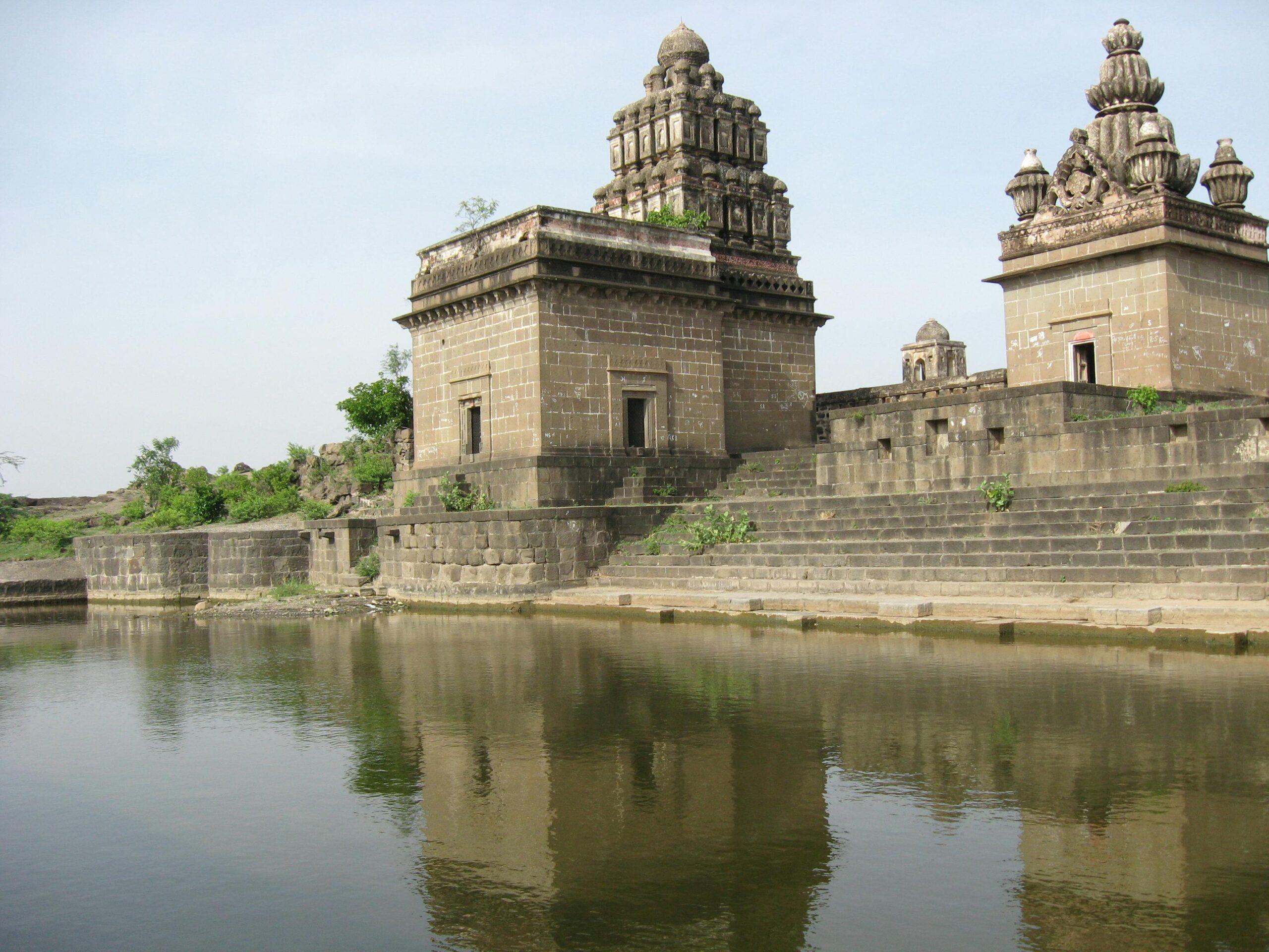 Ancient Hindu temple with reflection in water, located in Sangamner, India.