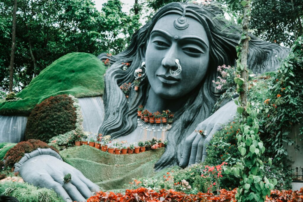 A grand woman statue surrounded by vibrant greenery in Chikmagalur, India.