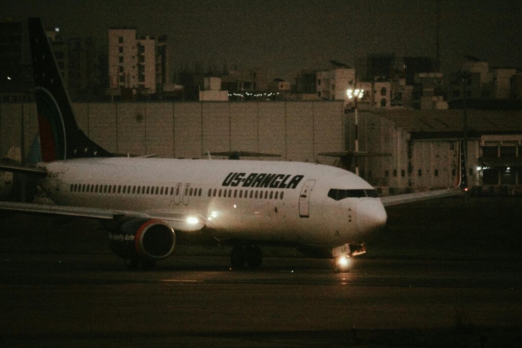 US-Bangla Airlines Boeing aircraft taxiing on runway during night at the airport.